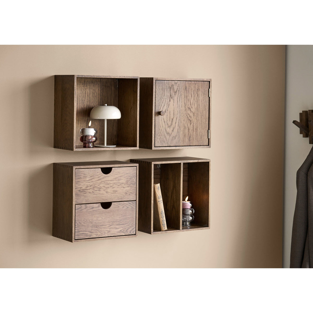 Lampe Margate Laque grège posée dans un cube mural en bois avec un photophore