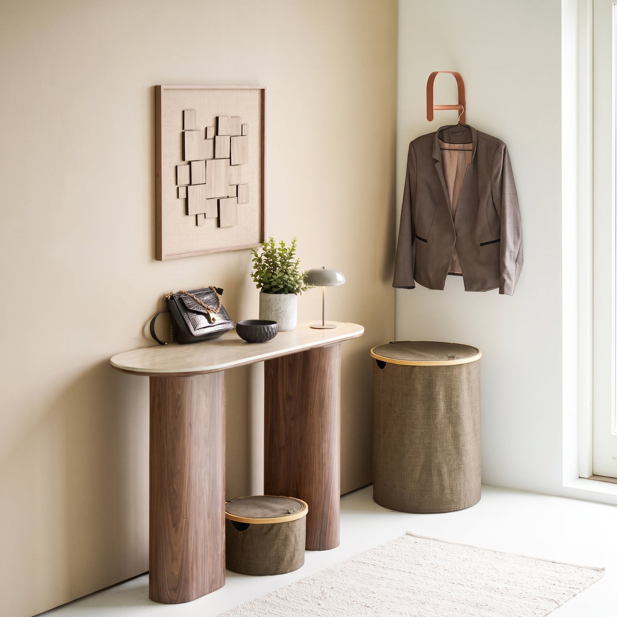 Lampe de table rechargeable Margate Laque taupe sur une console d'entrée, sous un tableau en relief et une veste suspendue