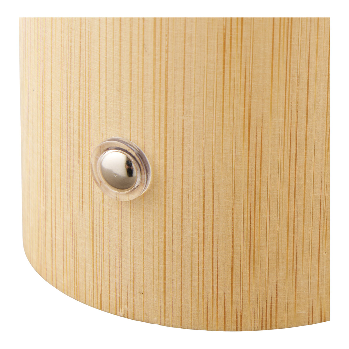 Gros plan sur le bouton rond en métal posé sur le socle en bambou de la lampe Stafford