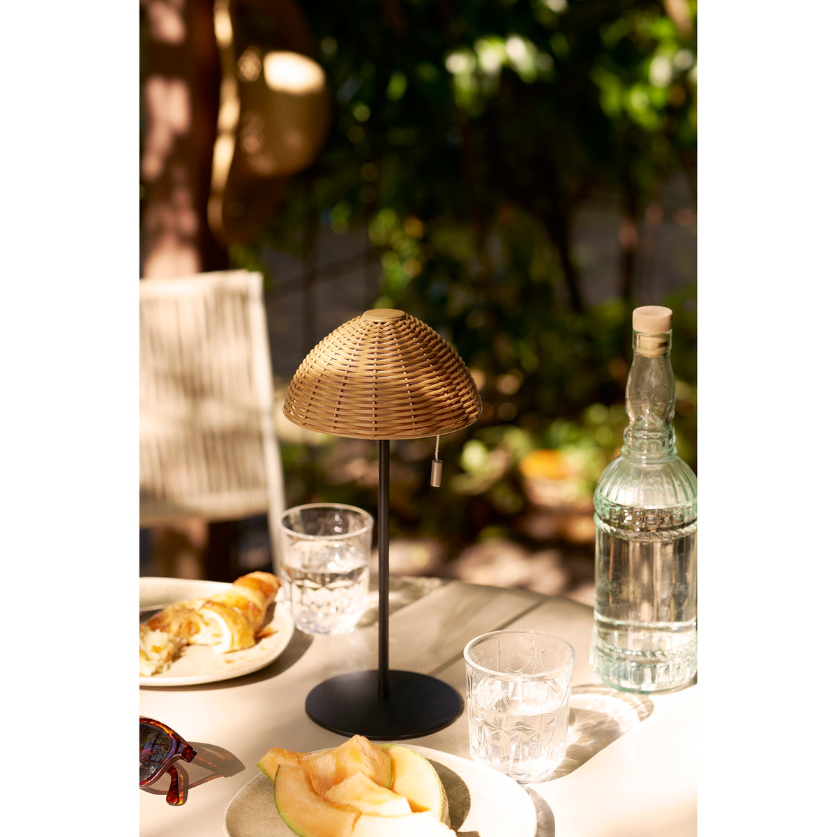Lampe Wigan sur une table de terrasse au petit déjeuner entre verres et carafe
