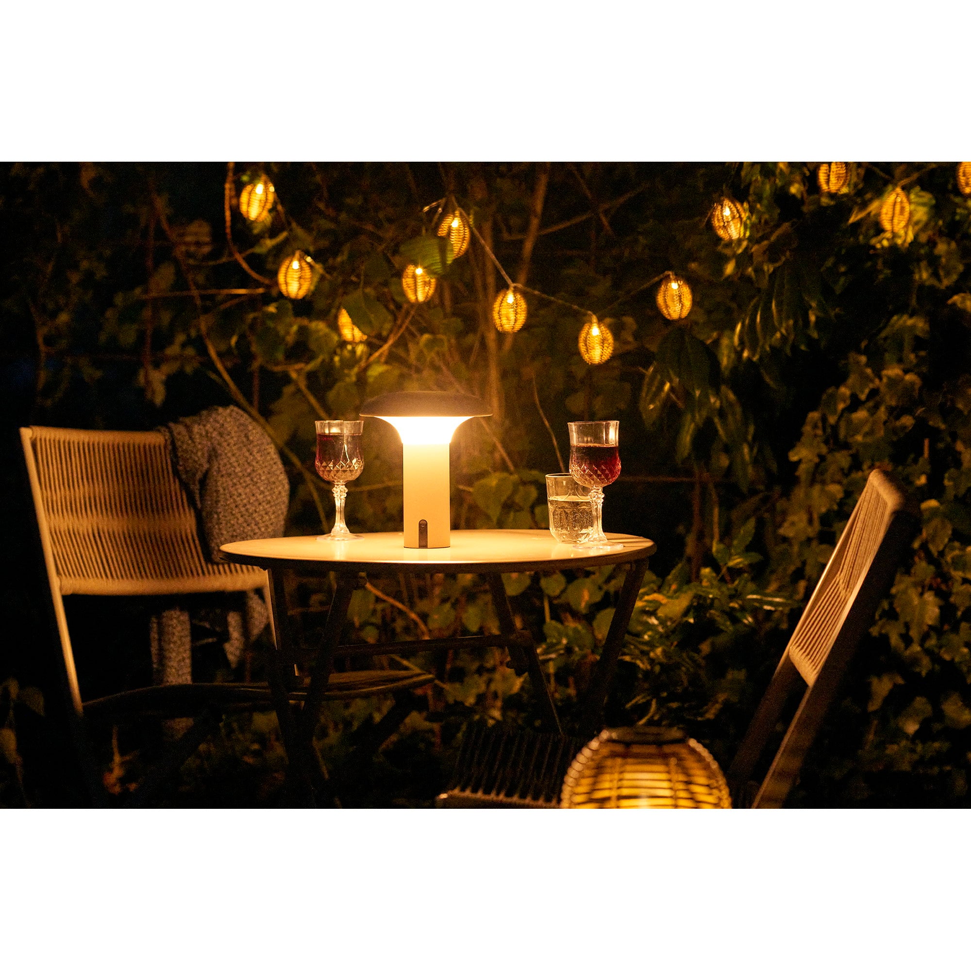 Lampe Ramsey beige sur table terrasse bois ensoleillée avec salon de jardin naturel