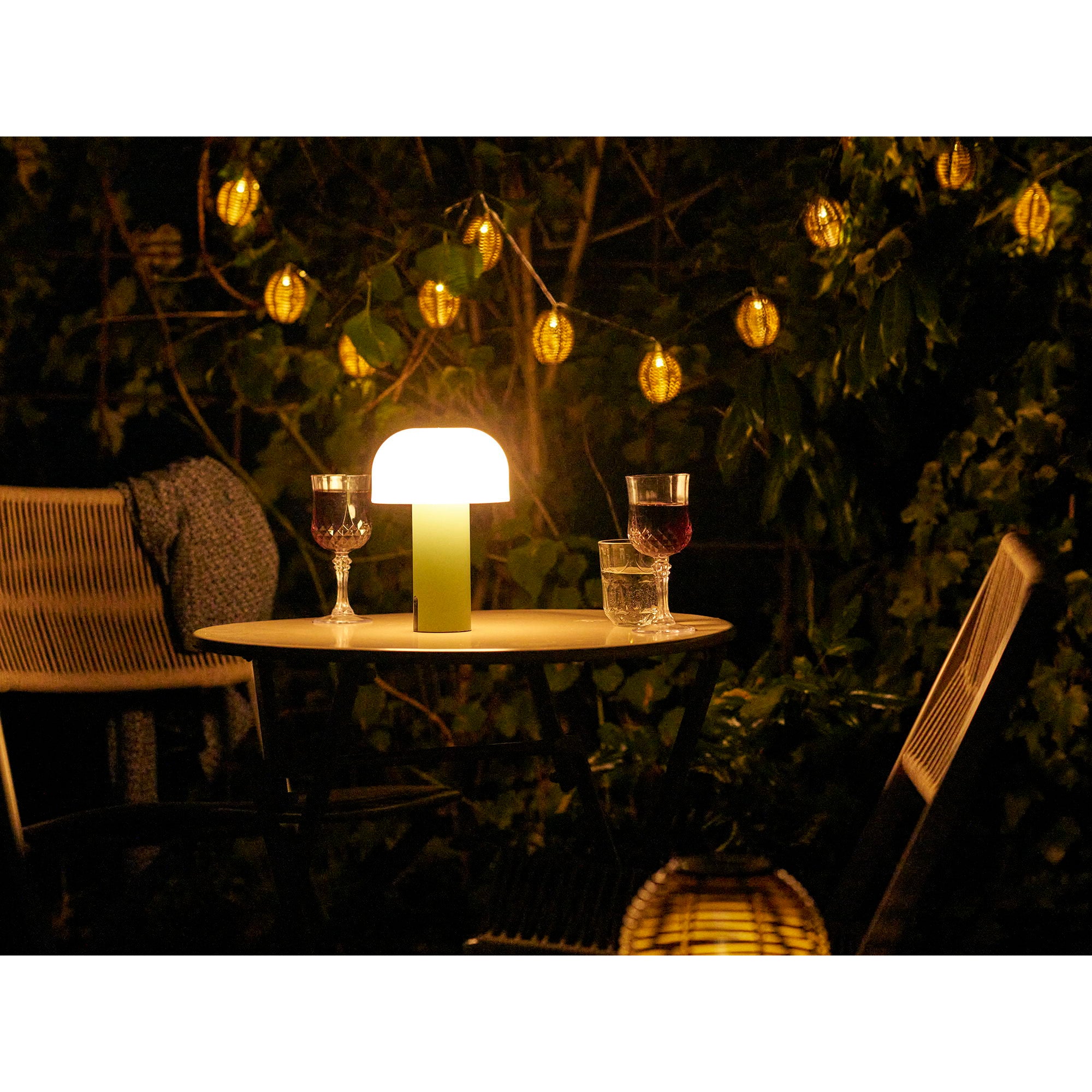 Lampe Soham LED verte allumée sur table de jardin nuit ambiance lumière chaude romantique