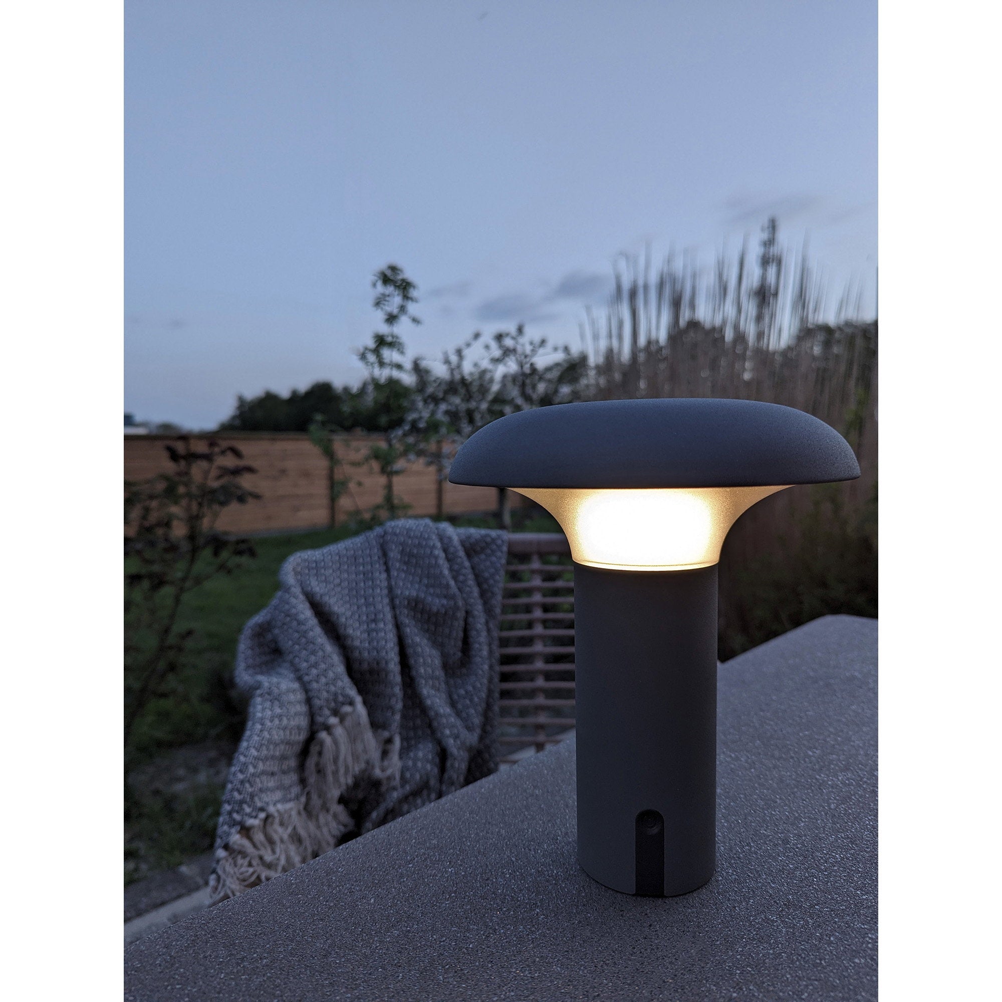 Lampe Ramsey gris mat allumée terrasse nuit ambiance chaleureuse extérieur soirée