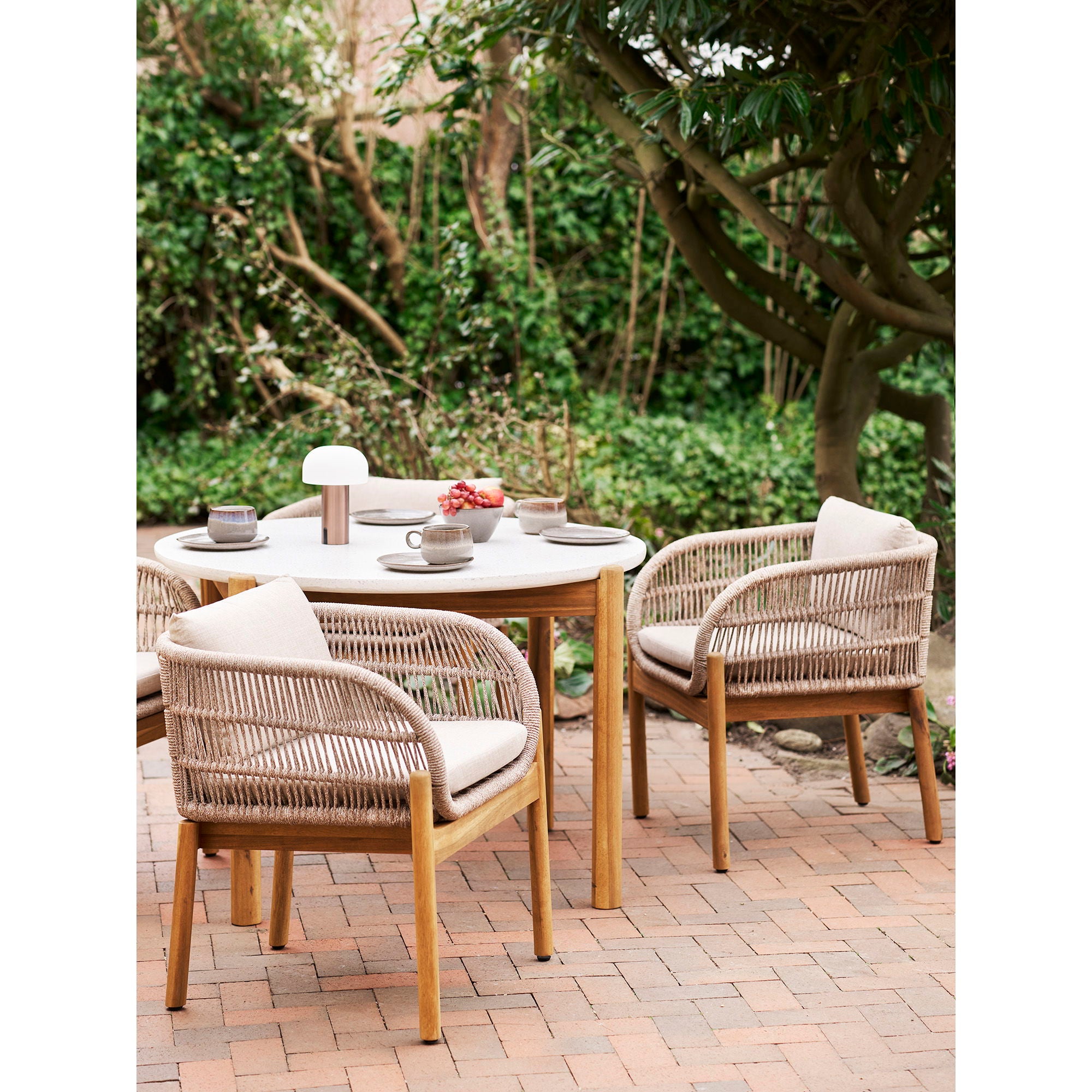 Lampe Soham cuivre brossé posée table jardin extérieur ambiance déjeuner nature