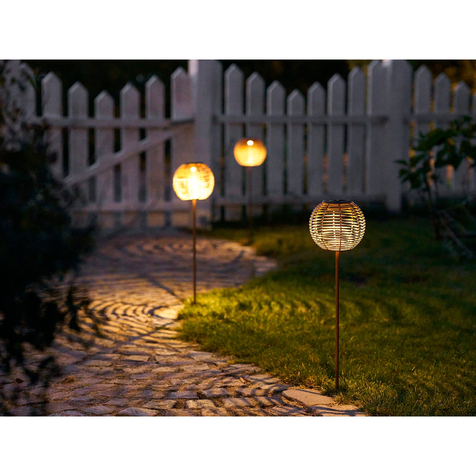 Lampes Carlisle allumées de nuit le long allée jardin ambiance féérique