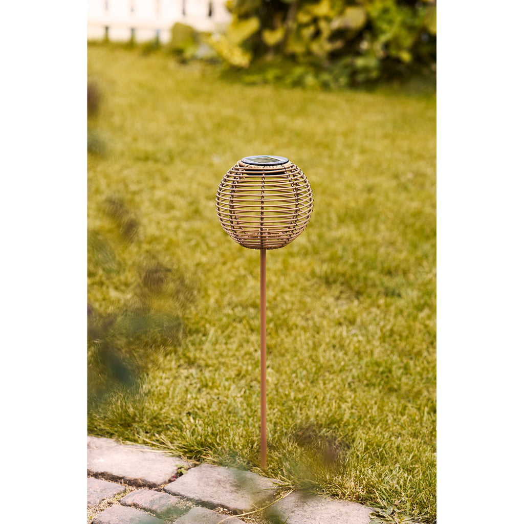 Lampe solaire Carlisle boule rotin naturel plantée seule dans gazon jardin