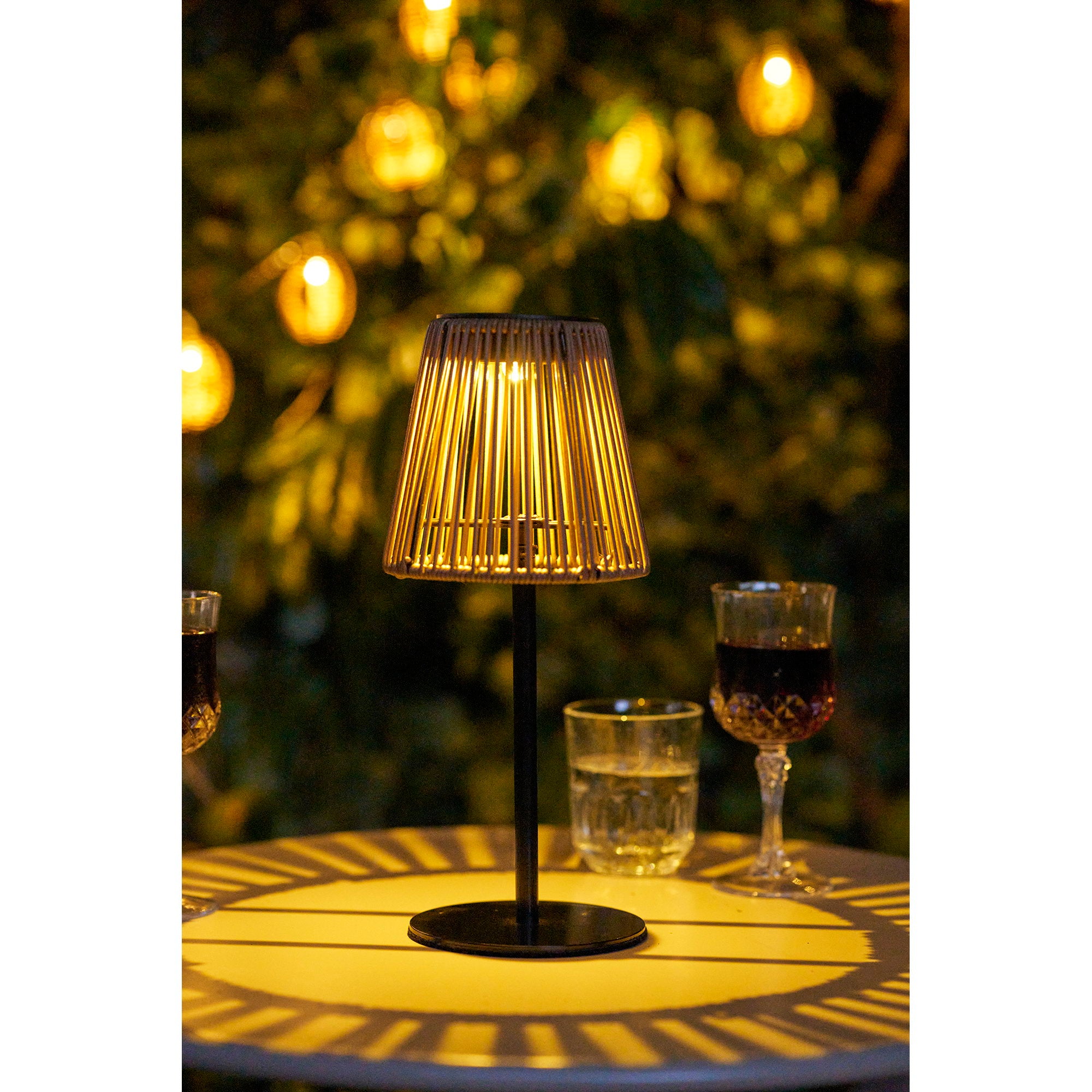Lampe Salford allumée en soirée sur table extérieure avec verres ambiance chaleureuse