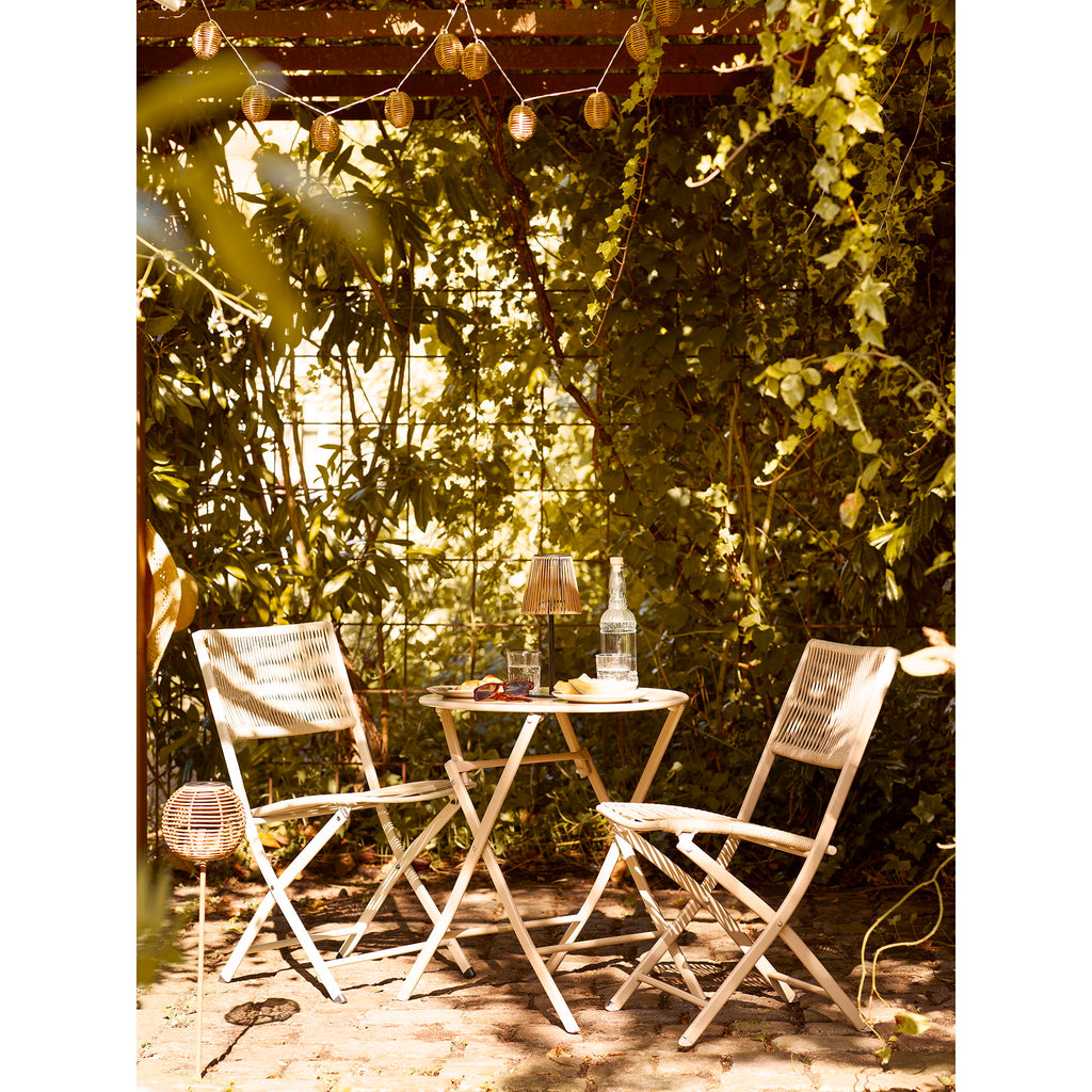 Lampe solaire Salford sur table bistrot terrasse jardin verdure lumière naturelle