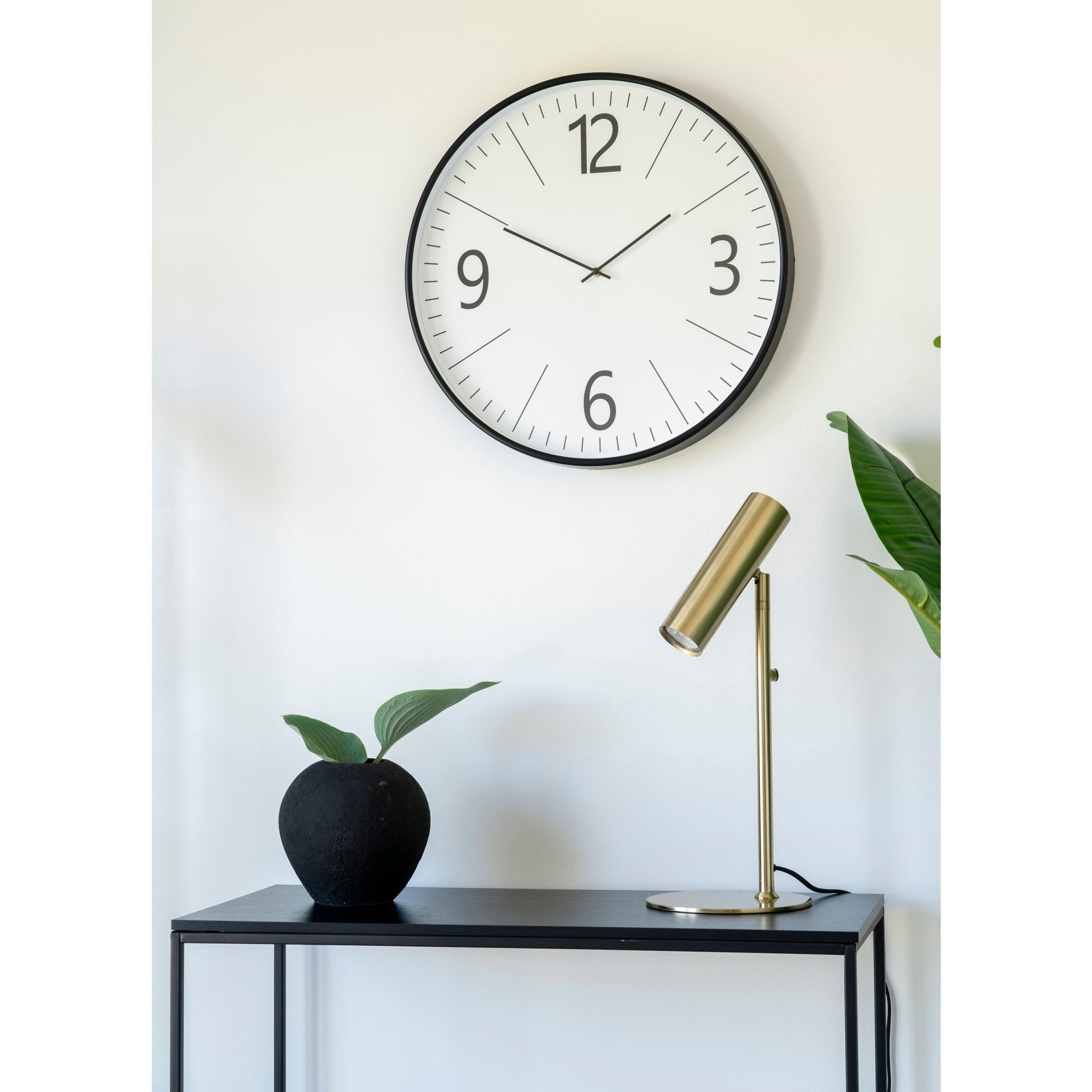 Lampe Paris laiton doré sur console noire avec horloge murale, décoration contemporaine