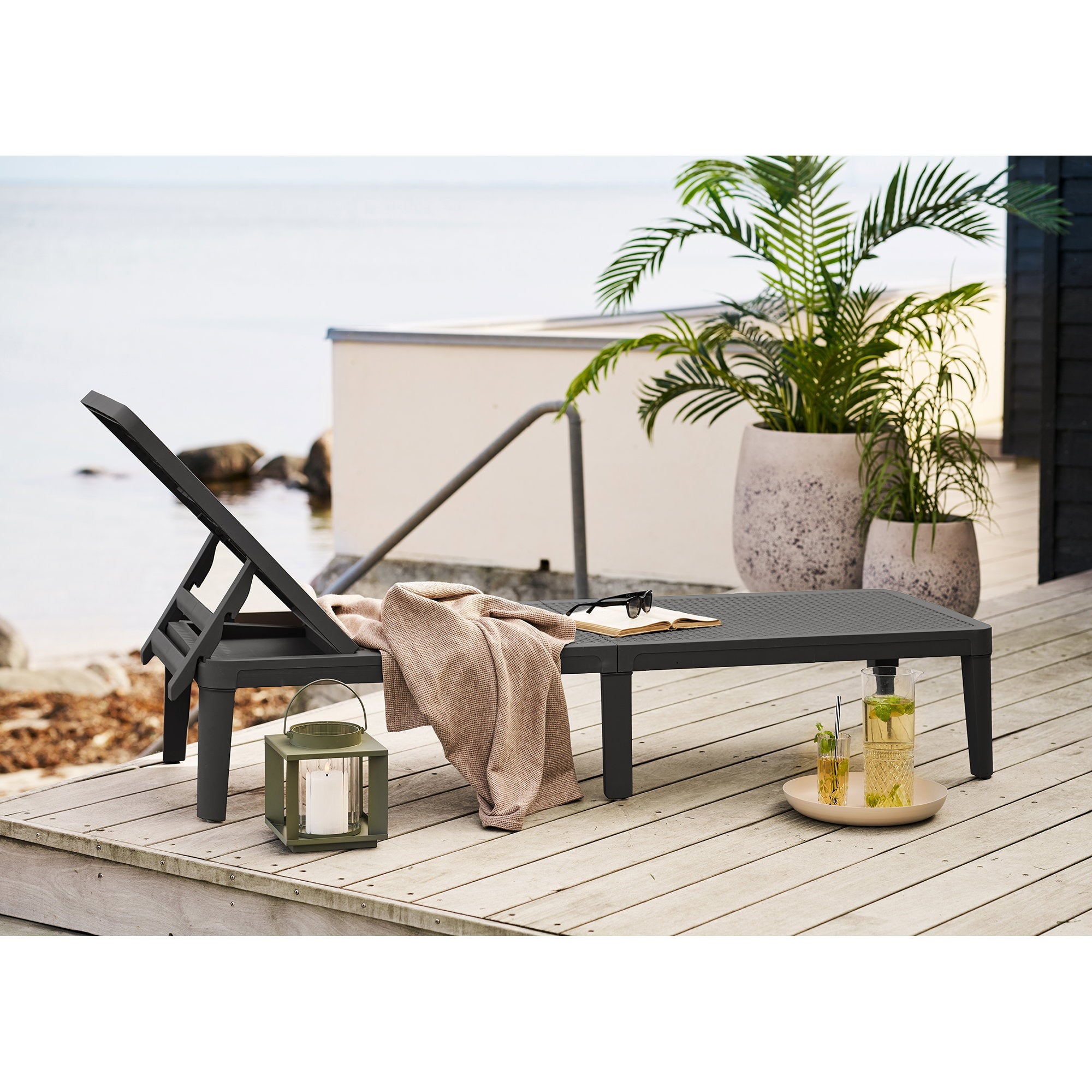 Lanterne Lohals vert kaki posée sur terrasse bois au bord de mer, ambiance cosy extérieur