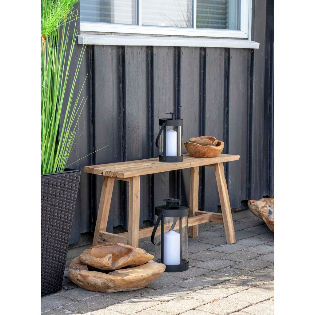 Lanternes Bondi noires posées sur table bois brut extérieur avec bol teck décoratif