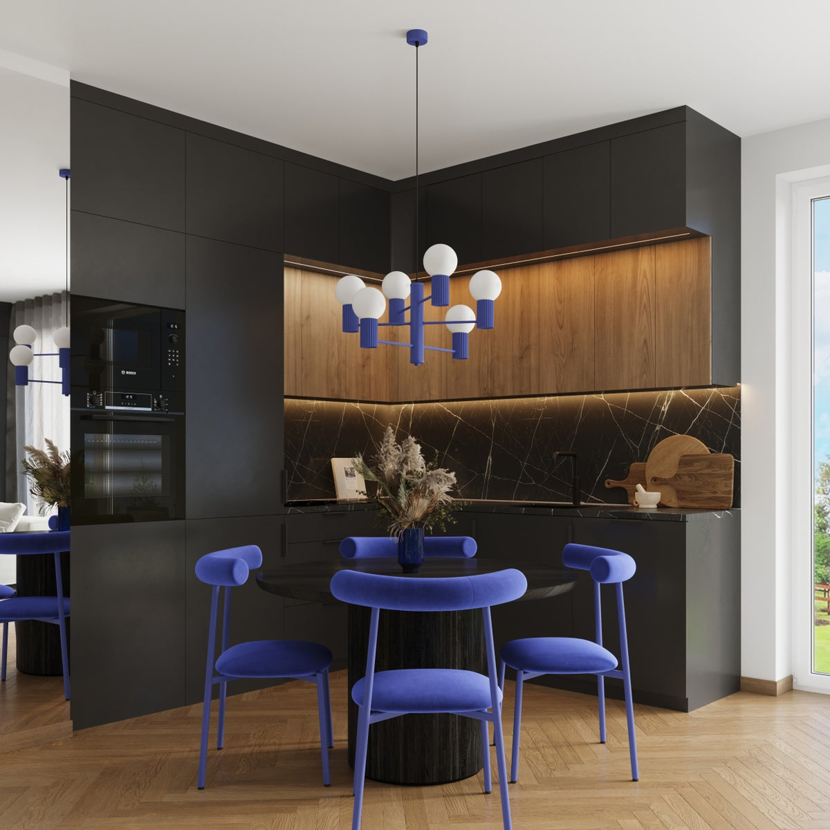 Lustre Halo laque bleu outremer au-dessus d'un coin repas dans une cuisine d'angle aux façades sombres et bois