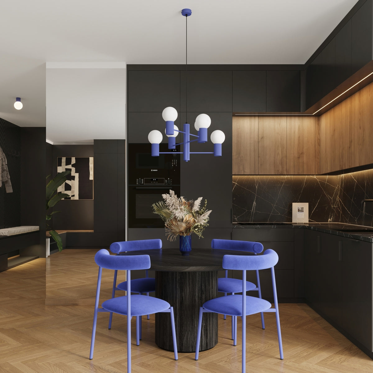 Lustre Halo laque bleu outremer au-dessus d'une table ronde en bois sombre entourée de quatre chaises dans une cuisine ouverte