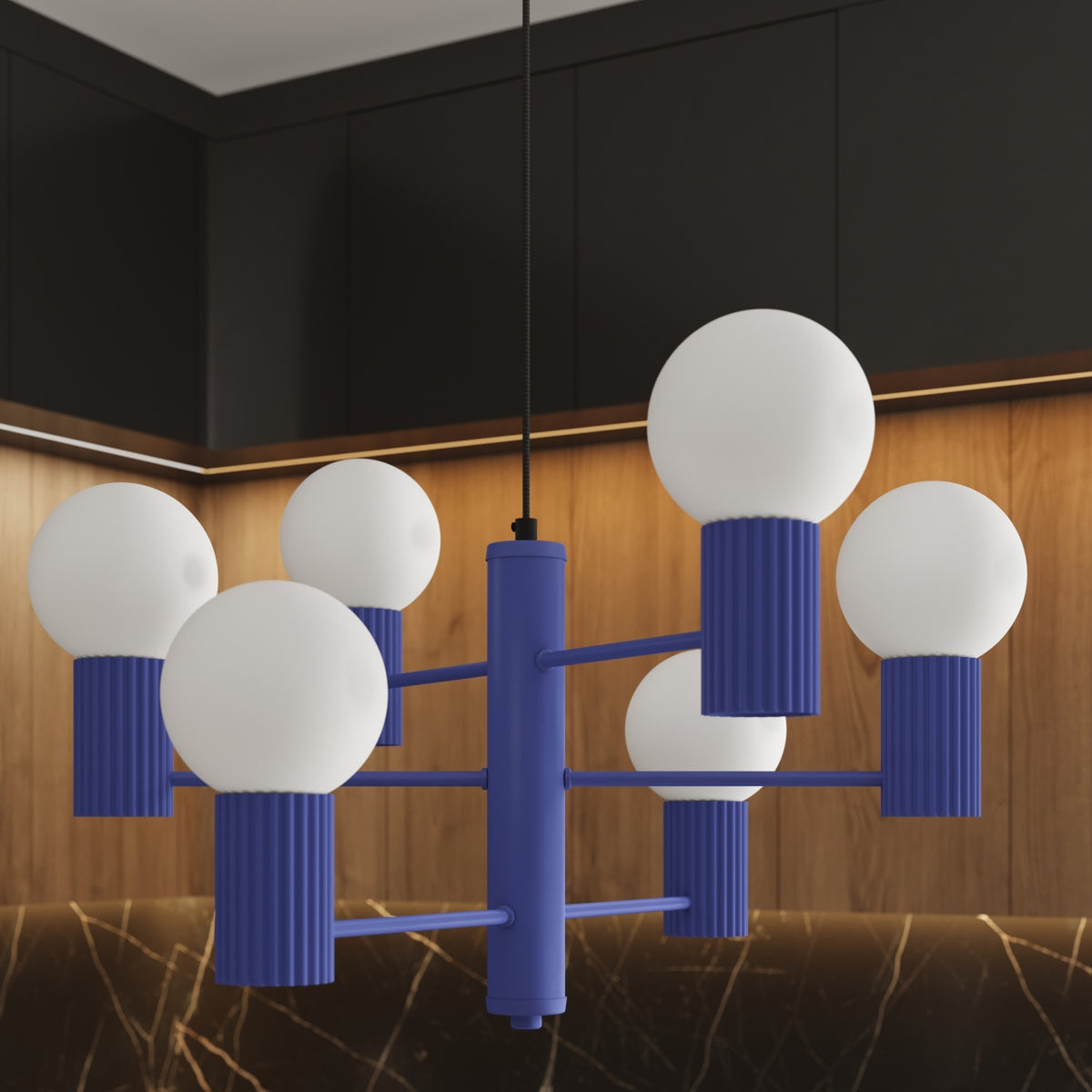 Gros plan du lustre Halo laque bleu outremer et de ses six boules opales devant des façades en bois éclairées