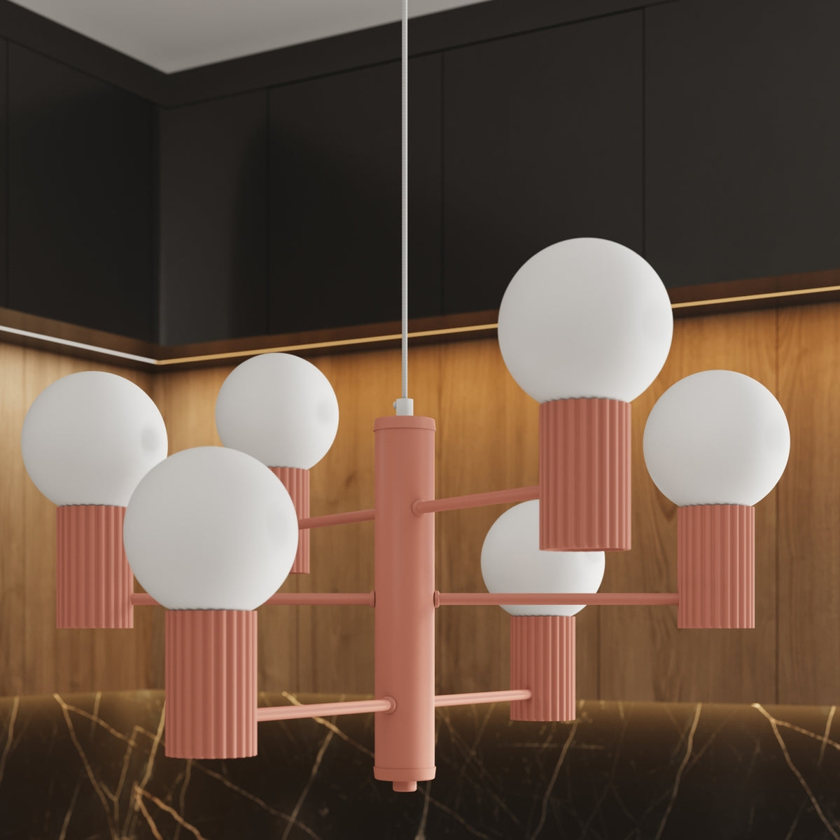Gros plan du lustre Halo laque rose pêche et de ses six boules opales devant des façades en bois éclairées