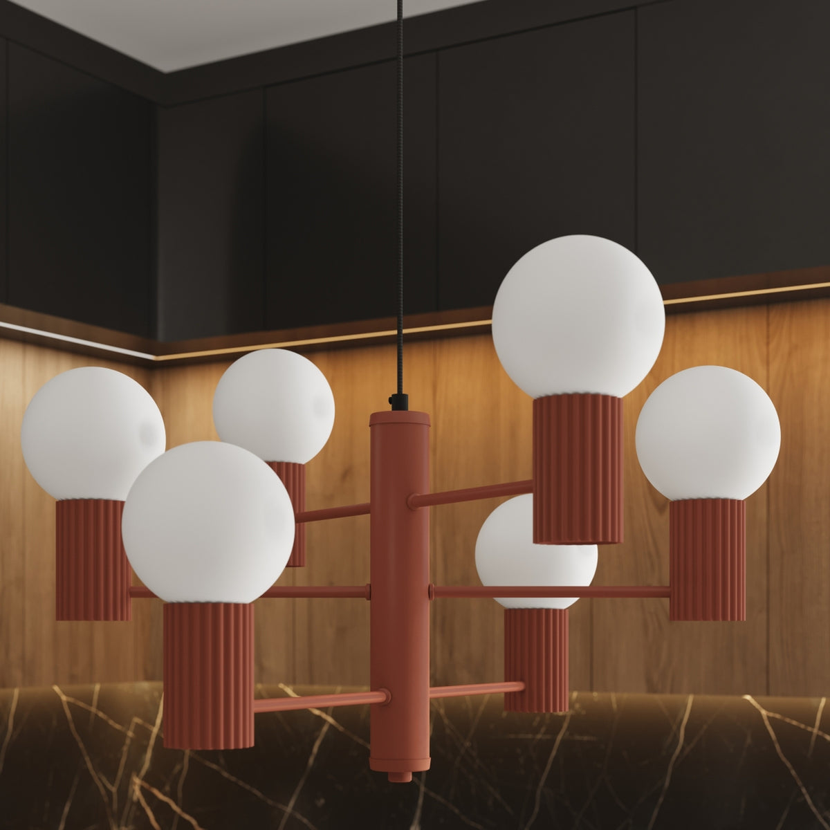 Gros plan du lustre Halo laque rouge ocre et de ses six boules opales devant des façades en bois éclairées