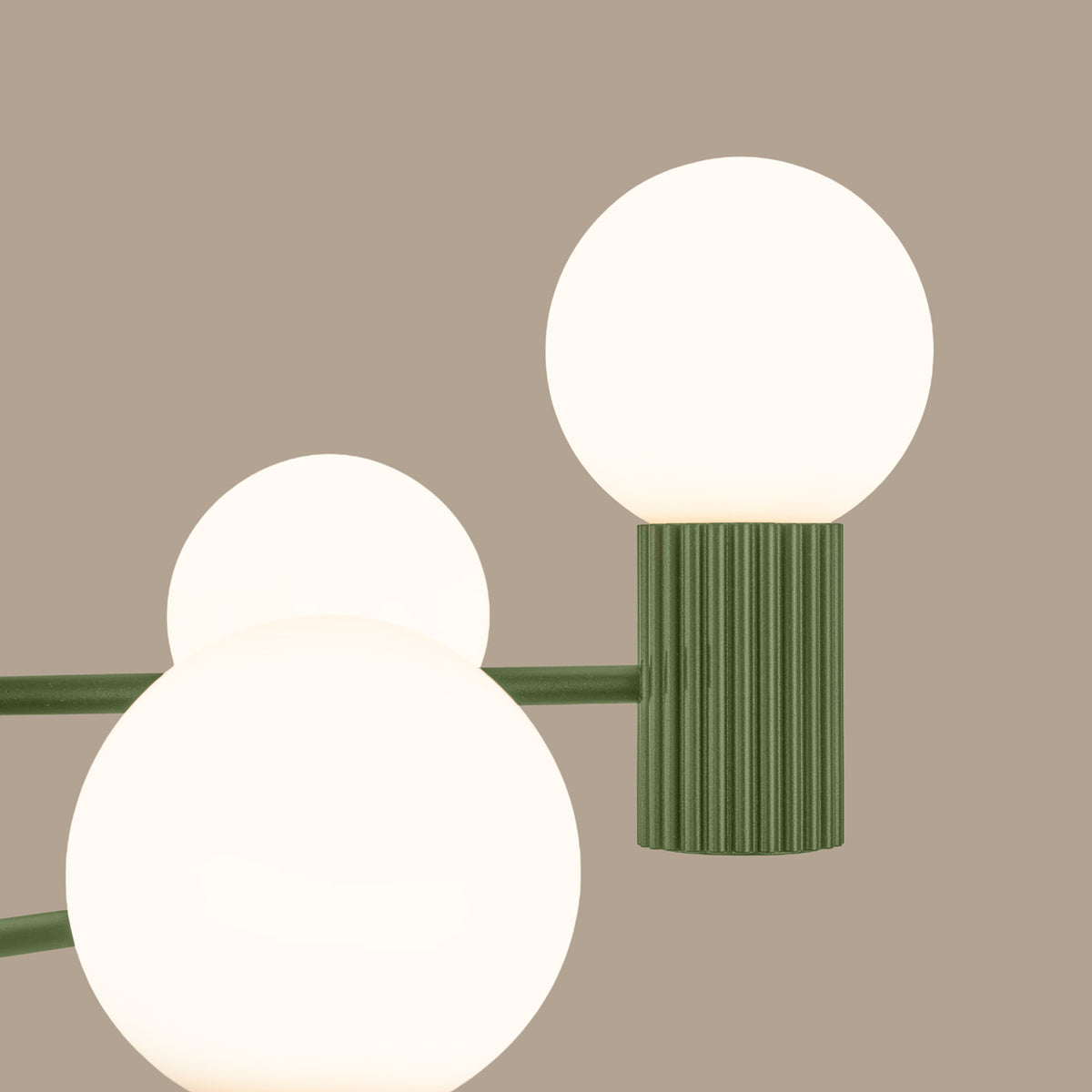 Gros plan des boules opales allumées sur leurs culots cannelés laque vert olive