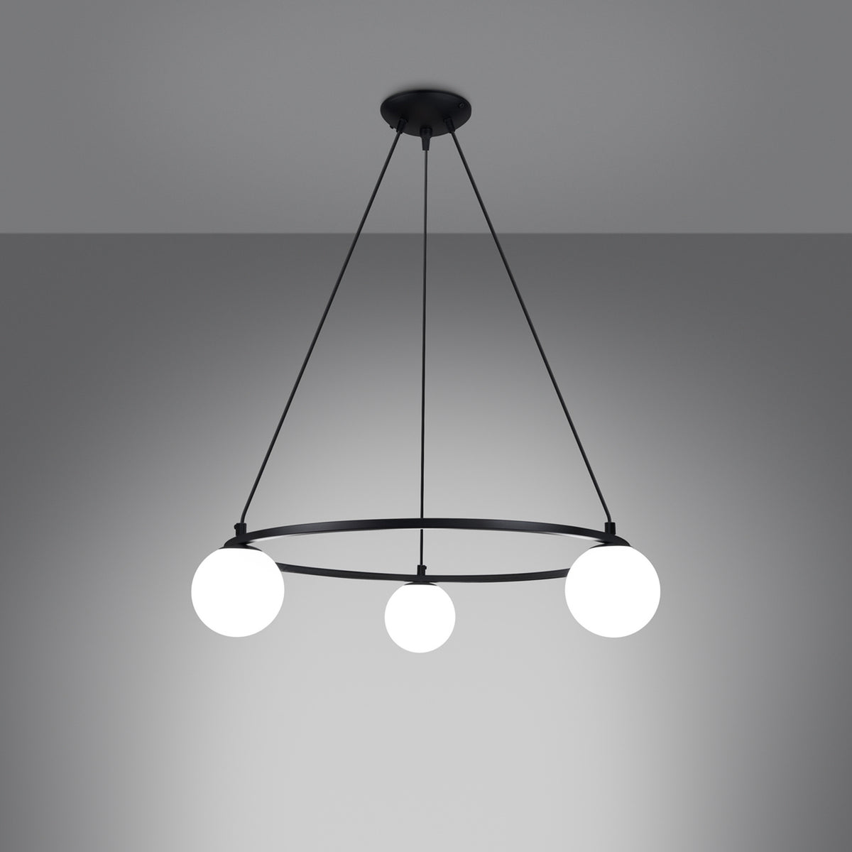 Lustre Yoli 3 allumé sur fond gris les trois boules de verre opale diffusent une lumière douce