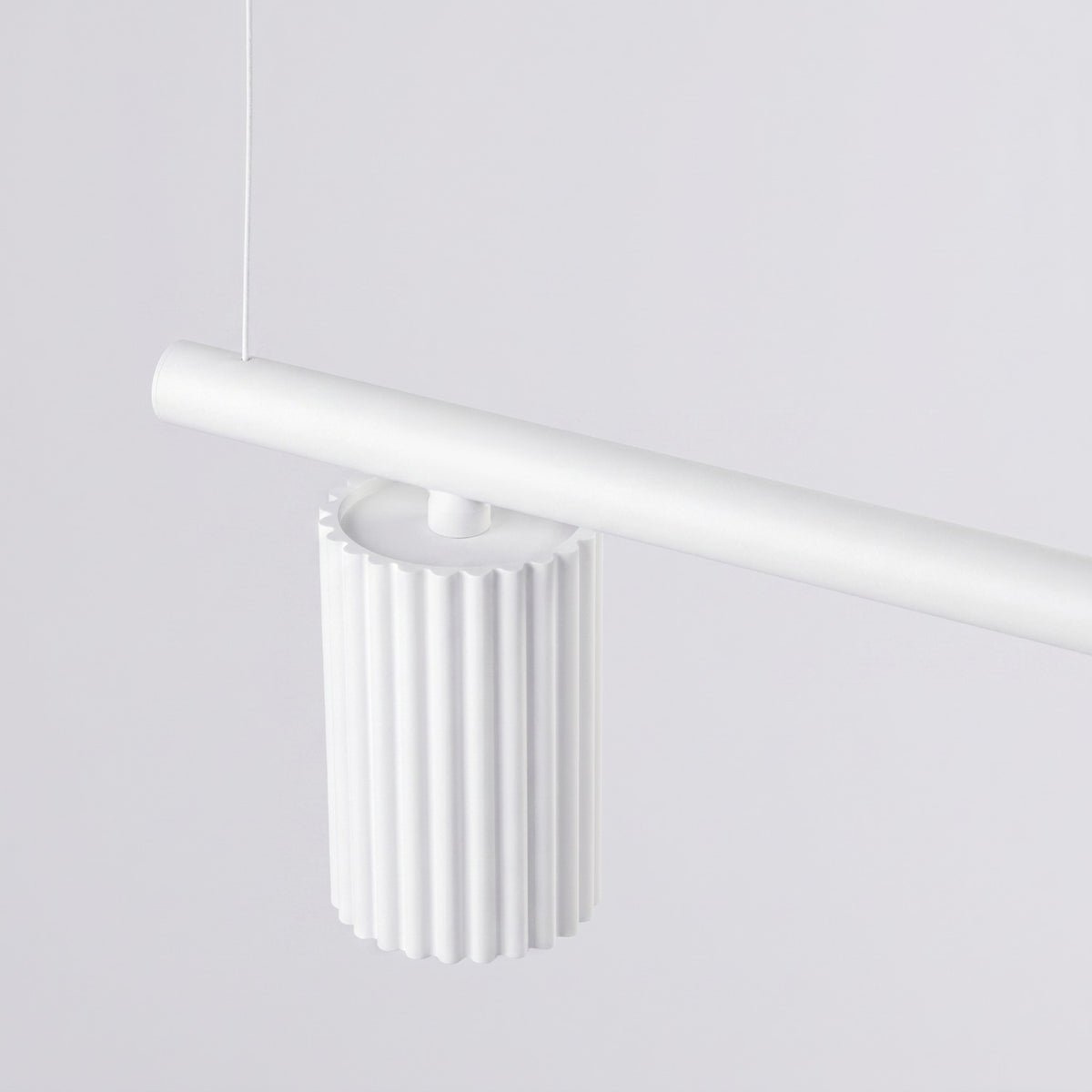 Spot cannelé laque blanche fixé sous la barre du lustre Karbon par une courte tige