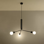 Lustre Duomo noir allumé avec ses trois ampoules globe éclairant un mur beige