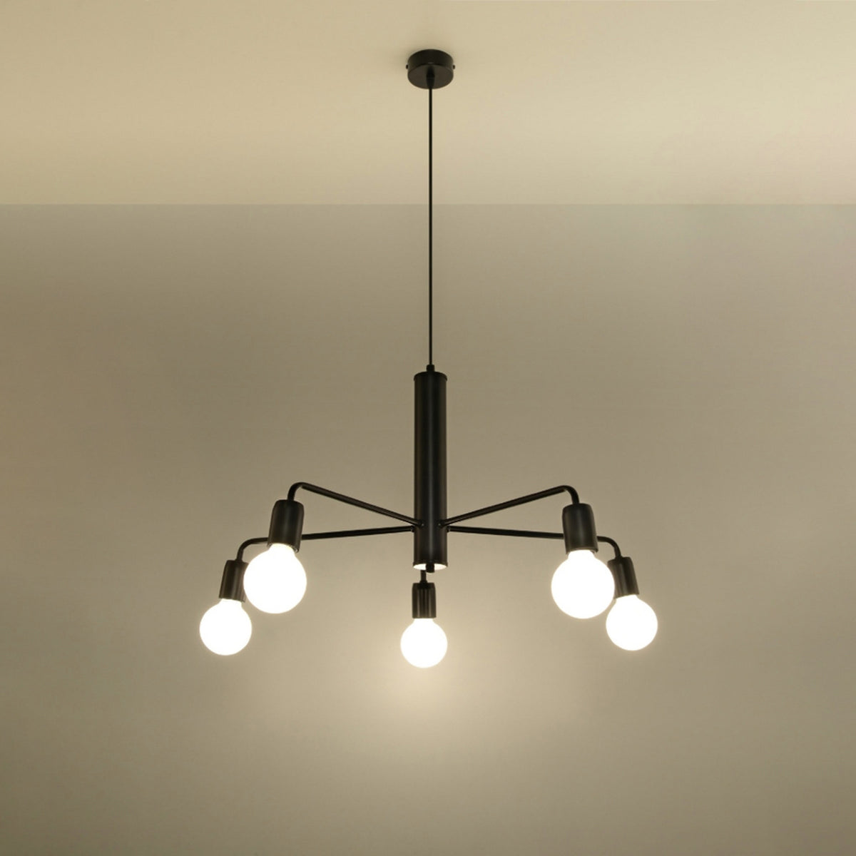 Lustre Duomo noir allumé sous un plafond clair avec ses cinq ampoules globes éclairées