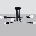 Lustre Norah à six branches noires vu sous un plafond blanc devant un fond gris