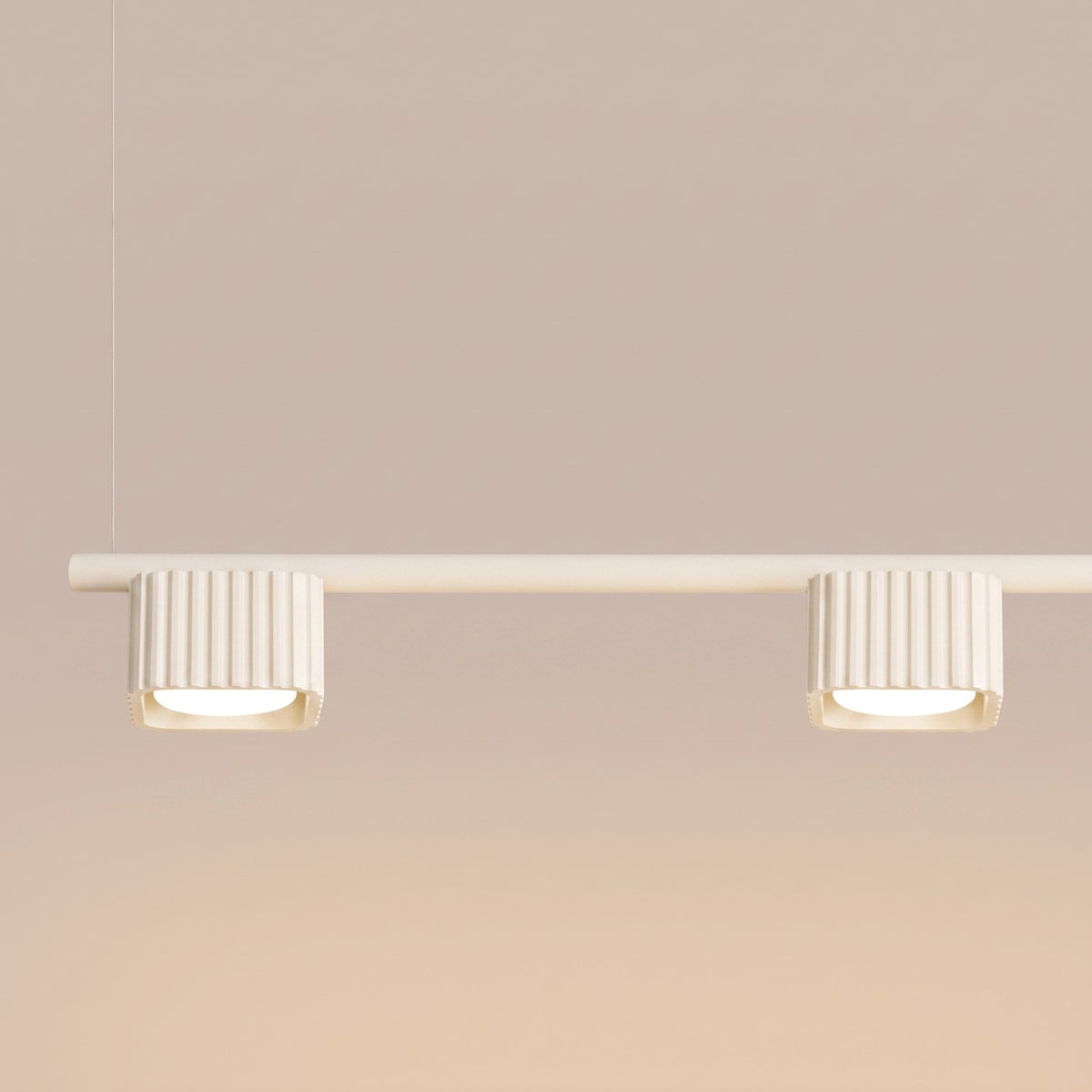 Deux têtes nervurées du lustre Riff 4 laque beige allumées sous la barre