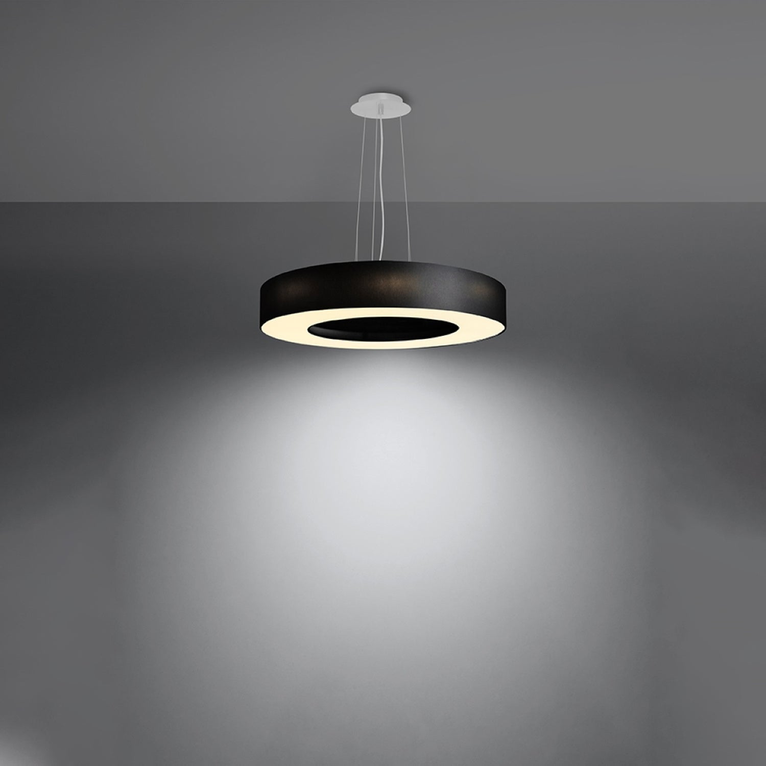 Lustre Saturno Slim 50 en tissu noir allumé, halo lumineux diffusé vers le bas