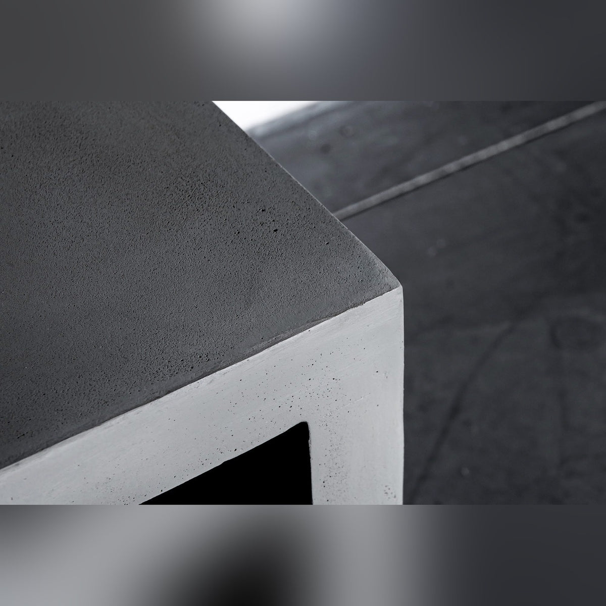 Angle du meuble TV Monobloc en béton photographié sur un sol en béton ciré