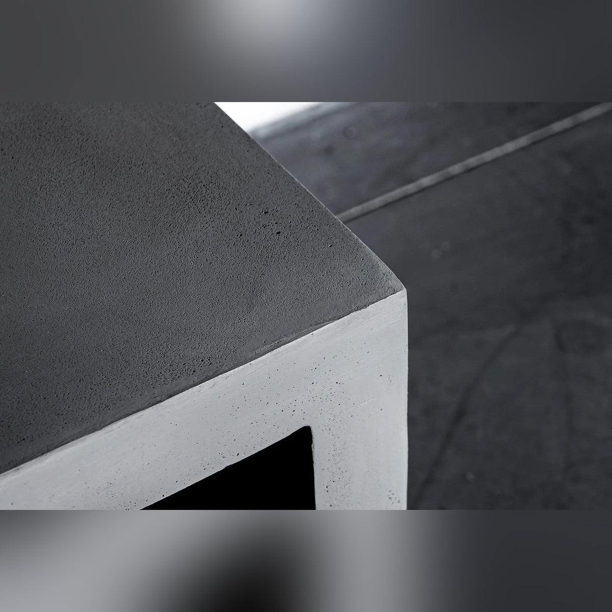 Gros plan sur un angle du meuble TV Monobloc et sur le grain mat du béton