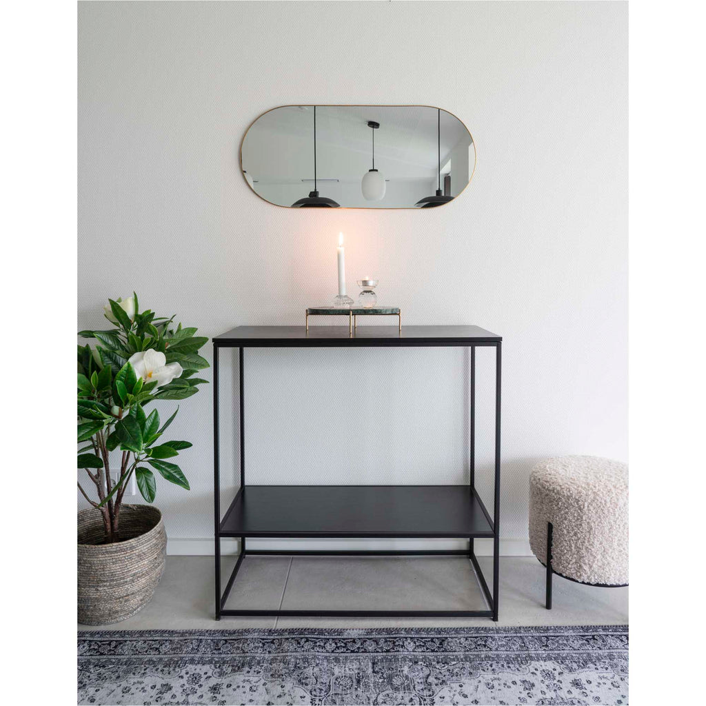 Miroir Jersey capsule laiton doré en horizontal au-dessus d'une console noire entrée