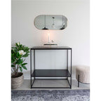 Miroir Jersey capsule laiton doré en horizontal au-dessus d'une console noire entrée