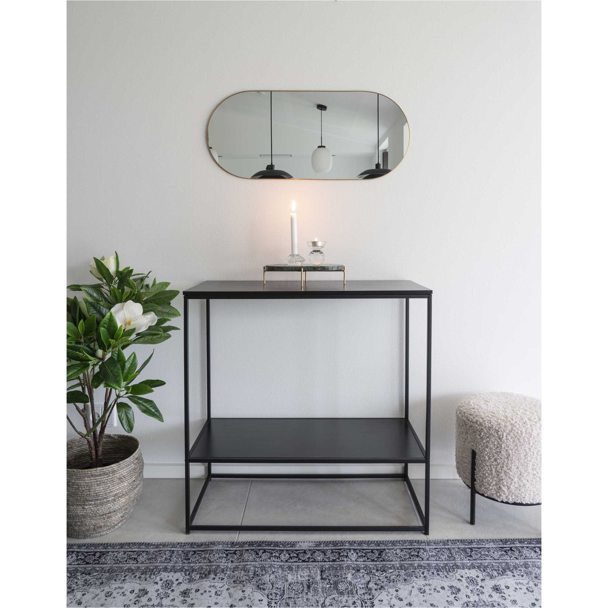 Miroir Jersey capsule laiton doré en horizontal au-dessus d'une console noire entrée