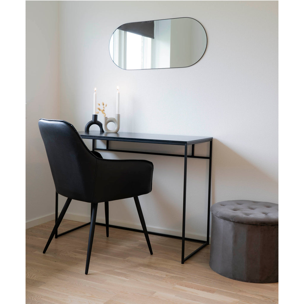 Miroir Jersey cadre noir forme capsule en horizontal au-dessus d'un bureau noir