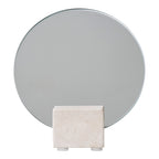 Miroir de table rond vu de face devant son bloc de travertin beige aux petites alvéoles