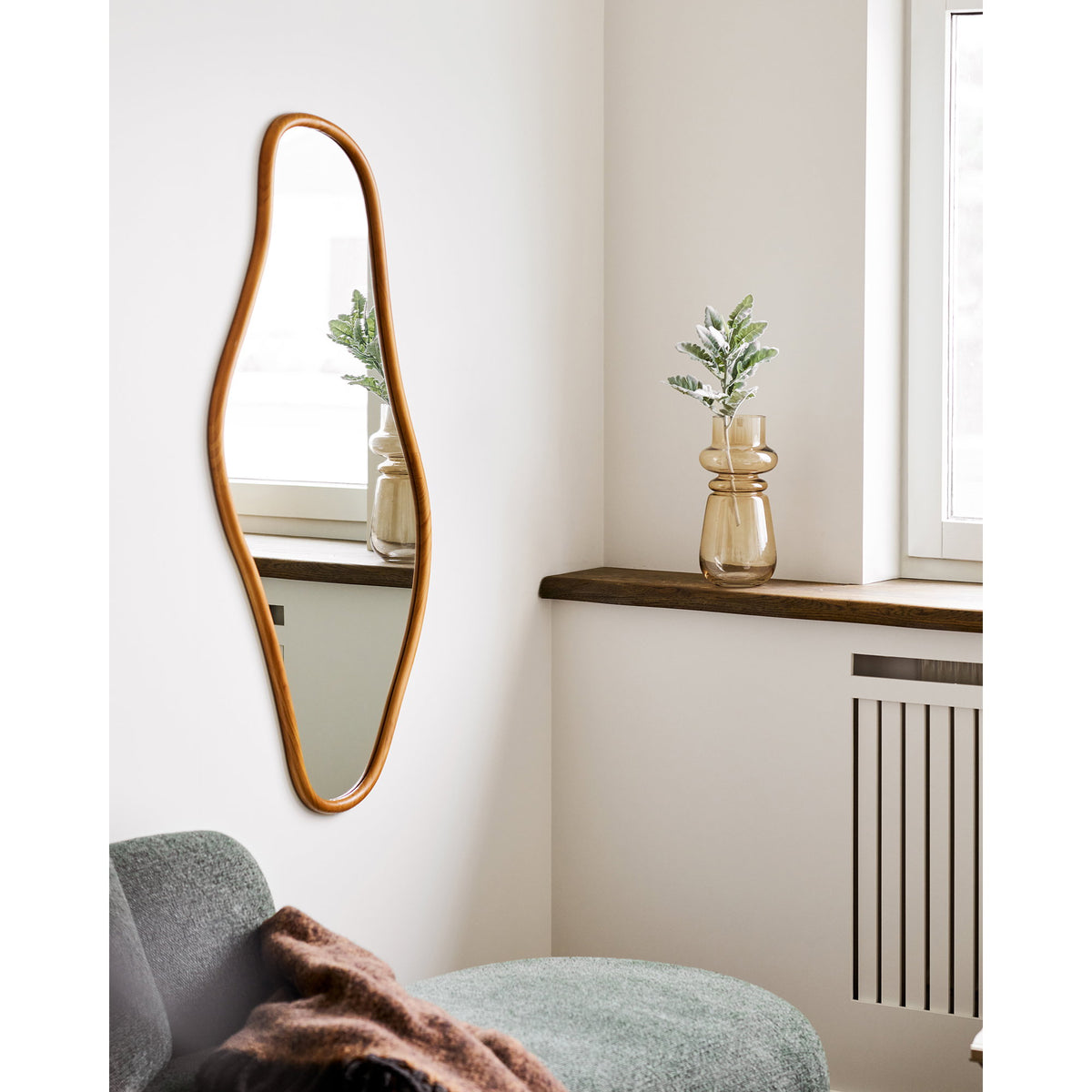 Miroir Brandsby en pin naturel près d'une fenêtre où se reflète un vase en verre ambré