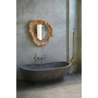 Miroir La Contessa au-dessus d'une baignoire grise près d'un balai en paille
