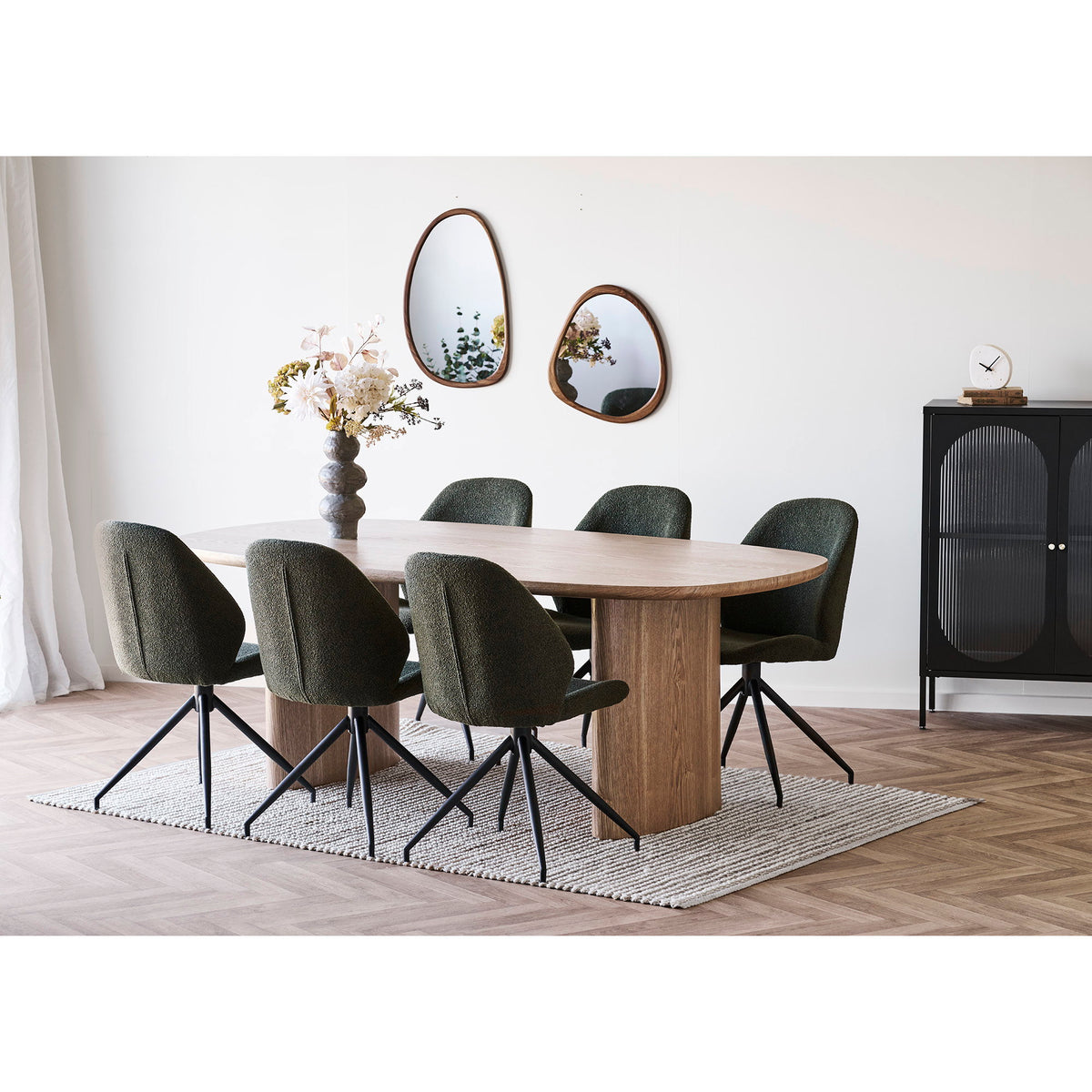 Deux miroirs Luxon décor noyer formats 38 x 64 cm et 44 x 47 cm au-dessus d'une table ovale entourée de chaises bouclées vertes