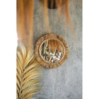 Miroir Tahiti sur un mur gris à côté d'une grande palme séchée