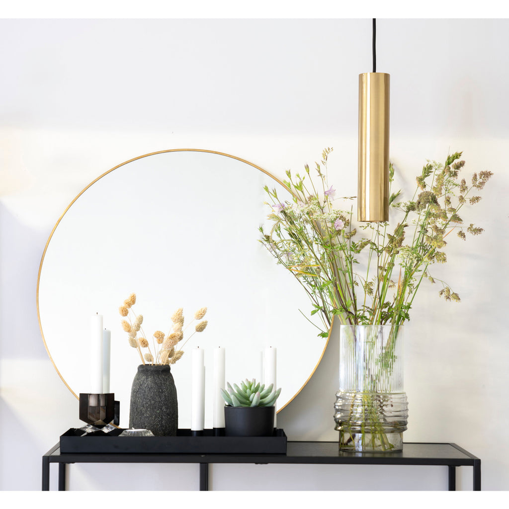 Miroir Jersey rond laiton doré ø60 cm au-dessus d'une console noire avec fleurs