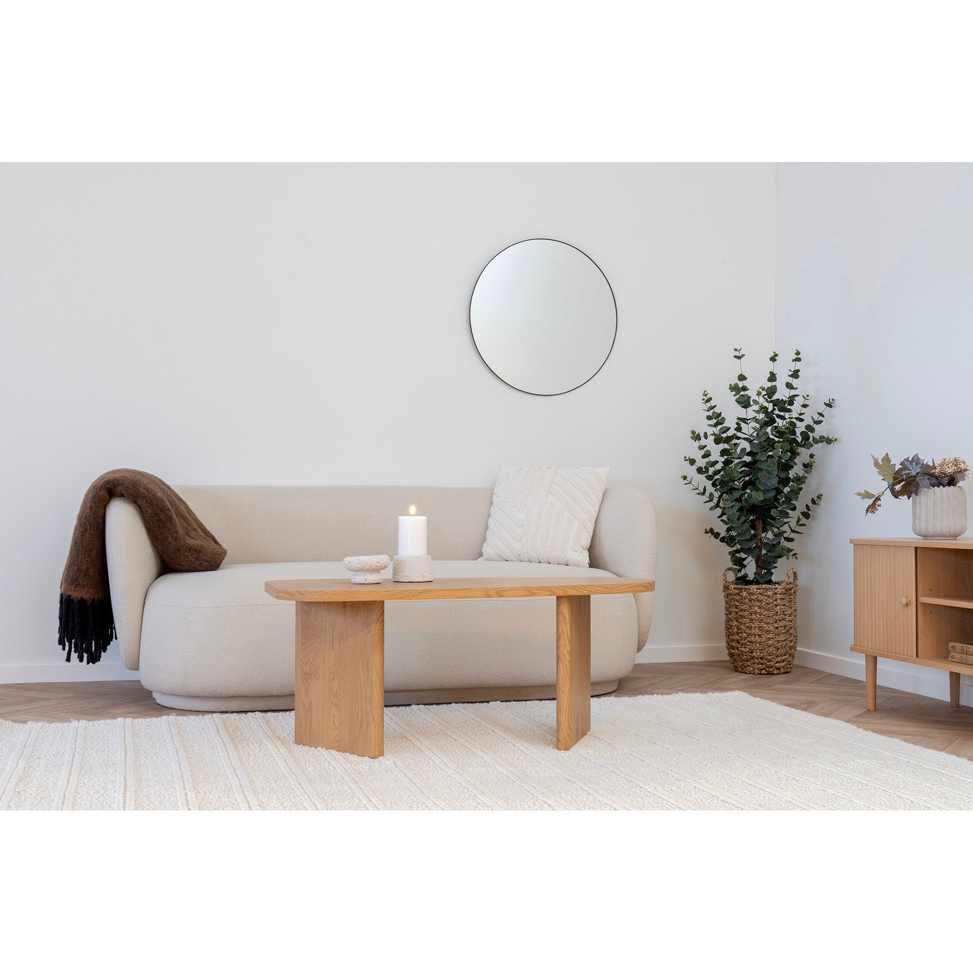 Miroir Jersey rond cadre noir au mur dans un salon contemporain canapé beige