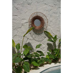 Miroir soleil Montezuma sur un mur en pierre grise au-dessus de plantes tropicales près d'une piscine