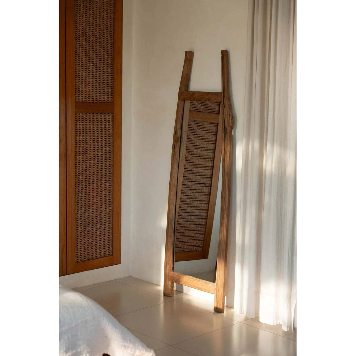 Miroir Fabulook adossé au mur d'une chambre à côté d'une armoire cannée