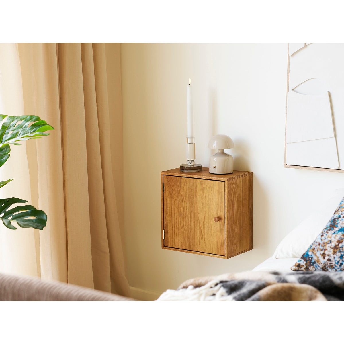 Module Townsville chêne naturel avec porte suspendu en chevet avec une bougie et une lampe à poser