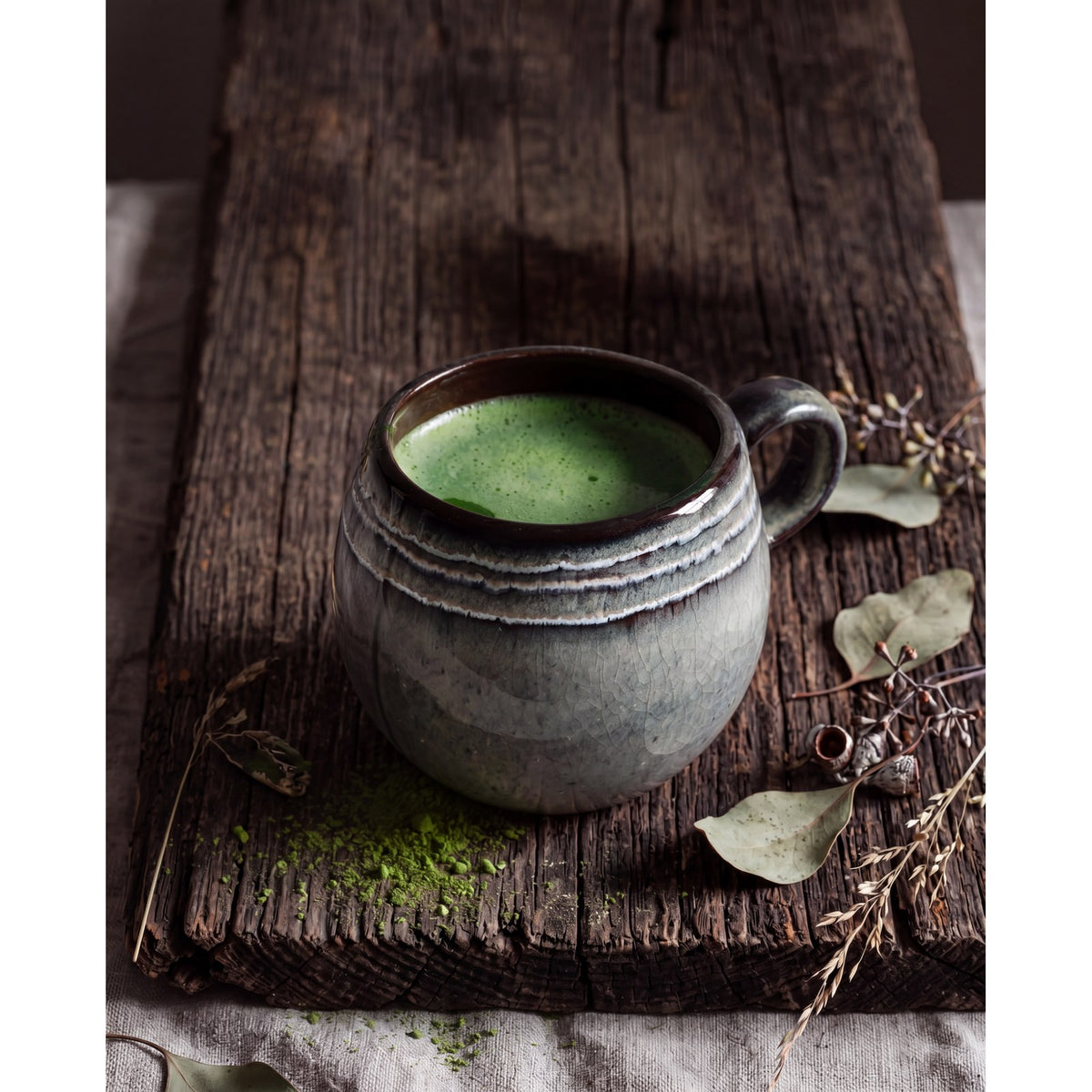 Mug boule Comporta rempli de matcha posé sur une planche en bois brut