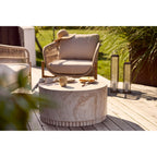 Mug Viola grès beige sur une table en travertin en terrasse avec fauteuil en rotin