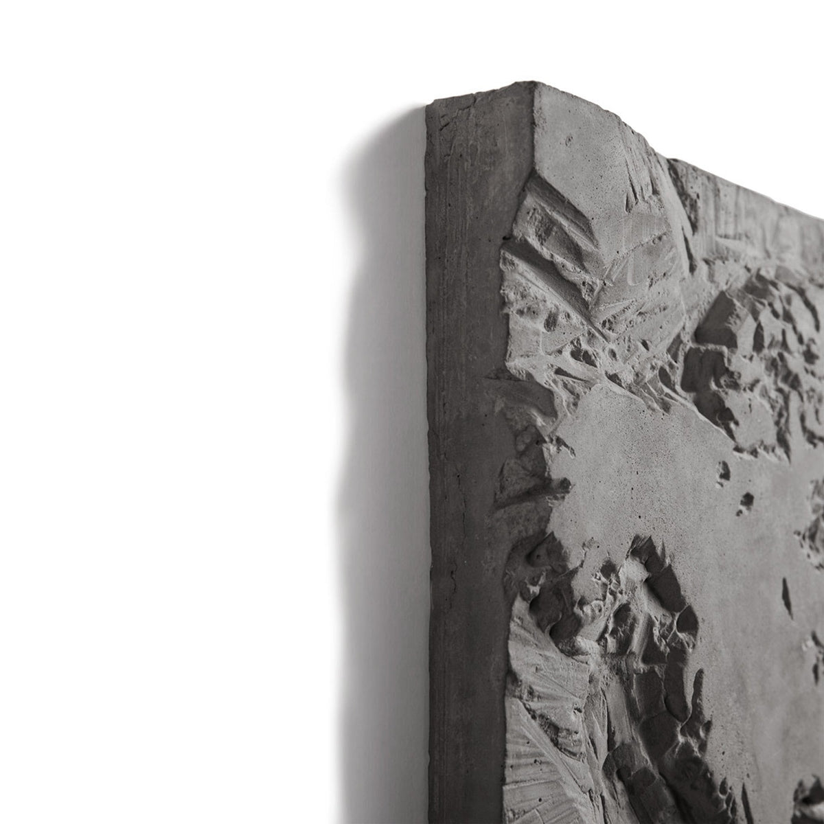 Angle de l'œuvre murale The Gray Planet avec la tranche du panneau en béton et le relief sculpté