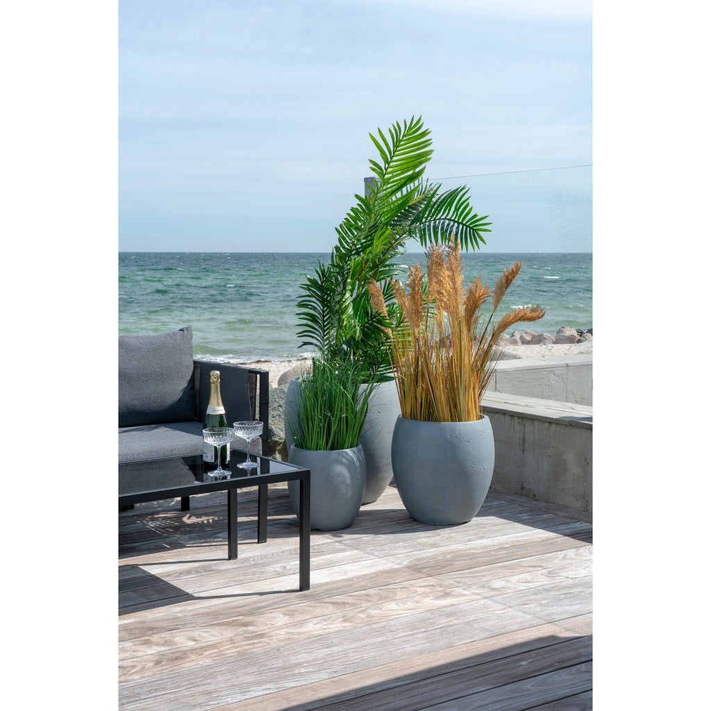 Grand palmier artificiel Areca dans pot béton terrasse bord de mer ambiance estivale