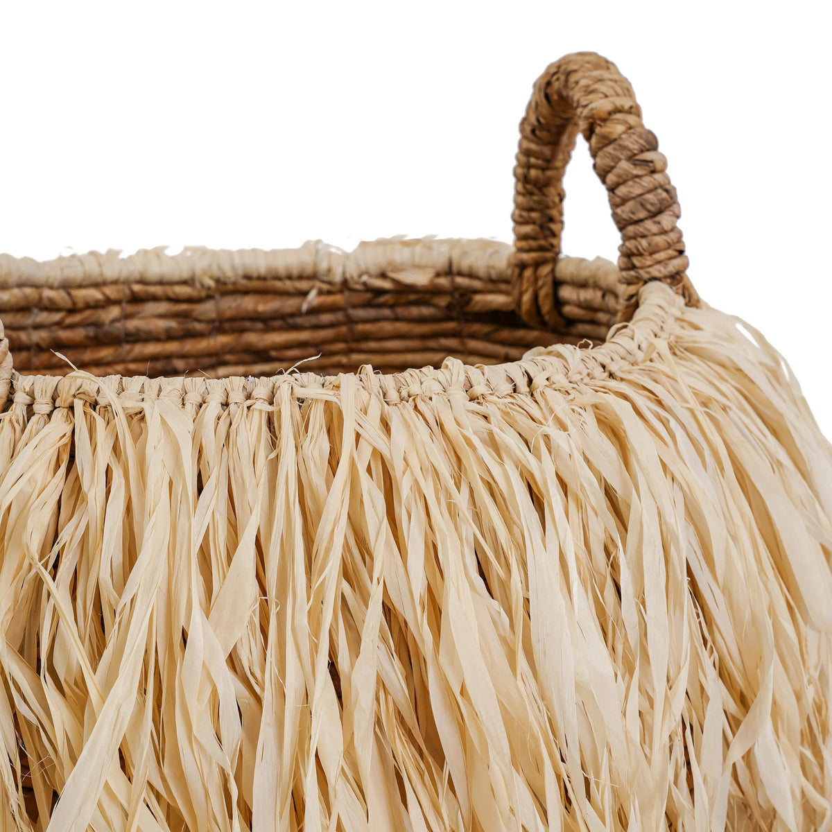 Détail d'une anse en feuille de bananier et de la frange de raphia nouée au bord du panier Raffia