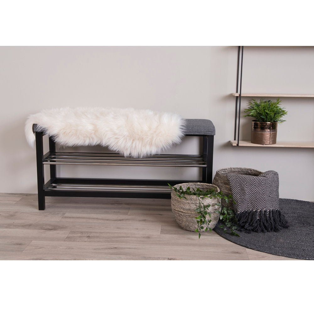 Fausse peau d'agneau ivoire drapée sur banc d'entrée noir ambiance scandinave lumineuse